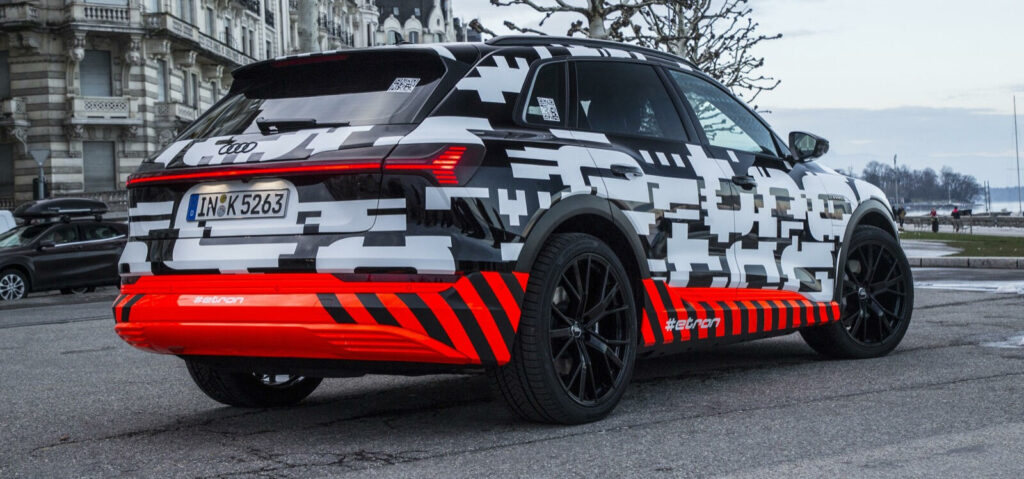 Audi Q3 EV i en stad. (AI text)