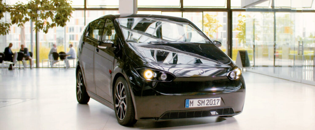 En svart bil parkerad i ett stort byggnad. (AI text)