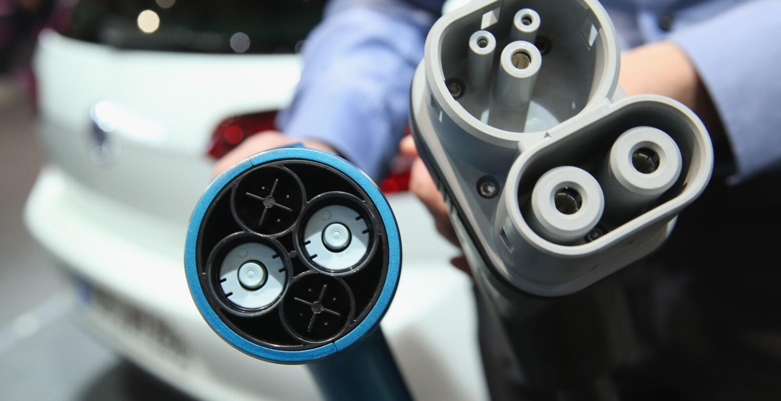 En man laddar sin bil vid bilutställningen. (AI text)