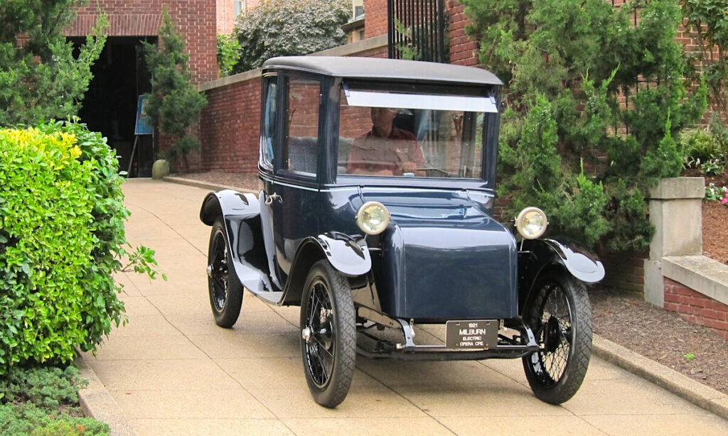 En återförsäljare av vintagebilar står parkerad framför en byggnad. (AI text)