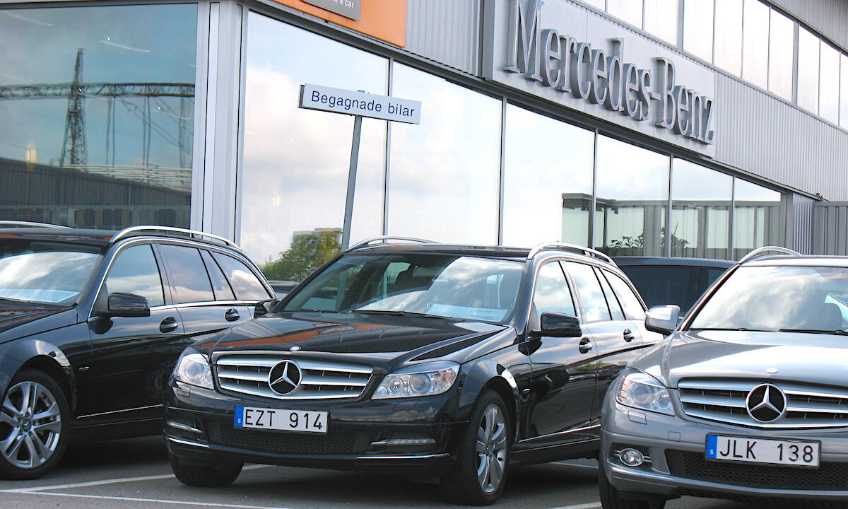 En Mercedes-Benz C-klass parkerad framför en bilhandel. (AI text)