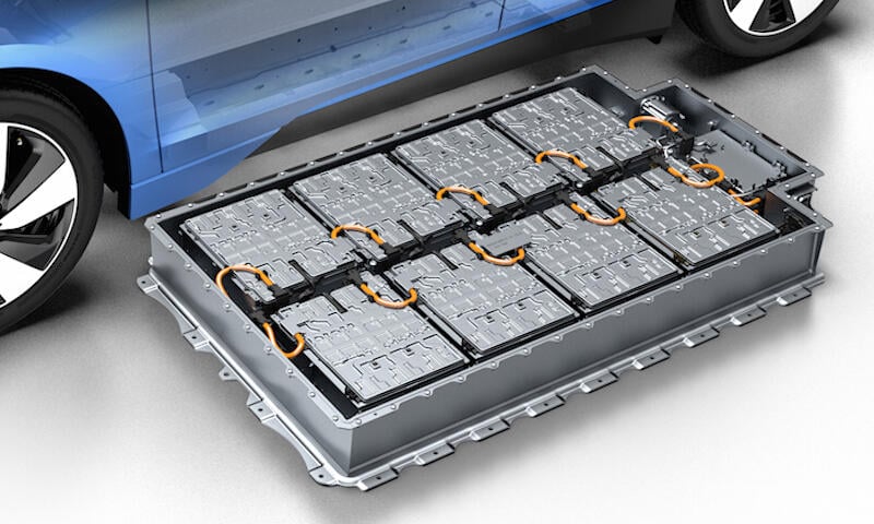 En blå bil med en batteri i bakluckan. (AI text)