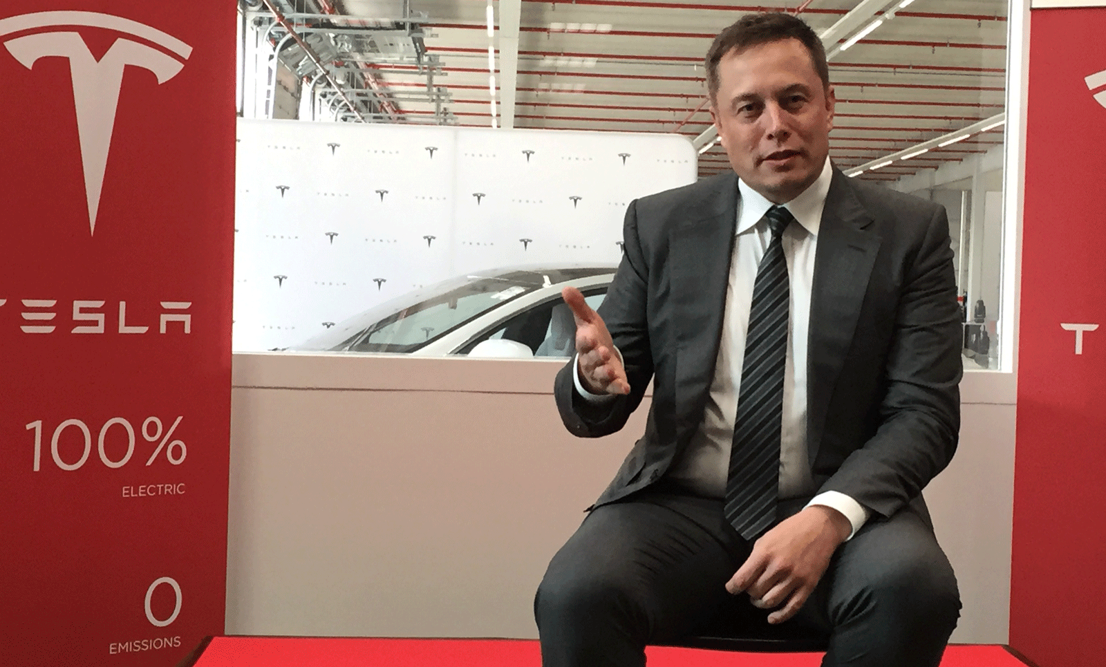 En talesperson från Tesla talar på företagets tillverkningsanläggning. (AI text)