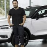 En man står bredvid en vit Volvo XC90. (AI text)