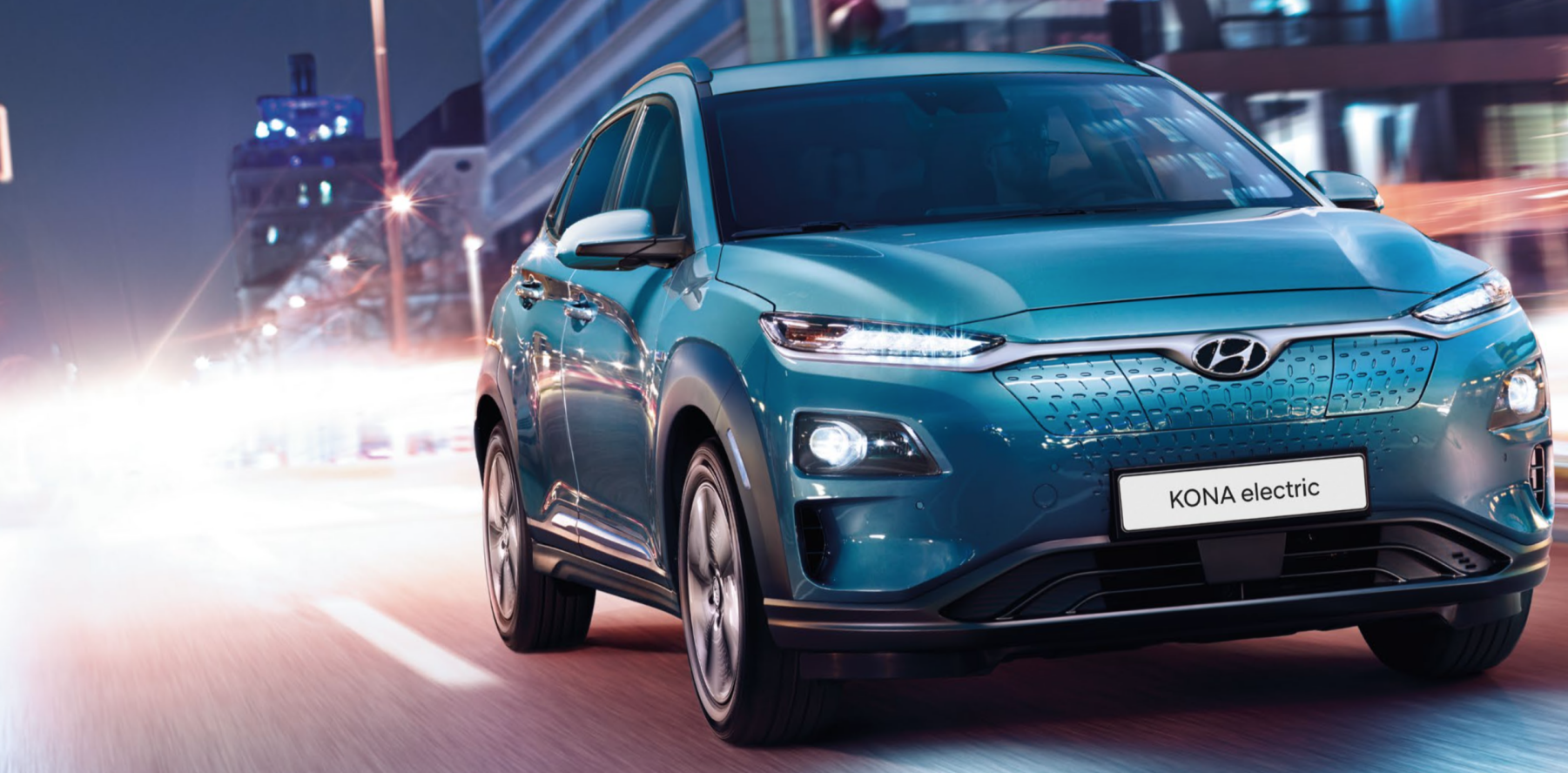 Den nya hyundai kona-elbilen kör nedför en stadsgata på natten. (AI text)