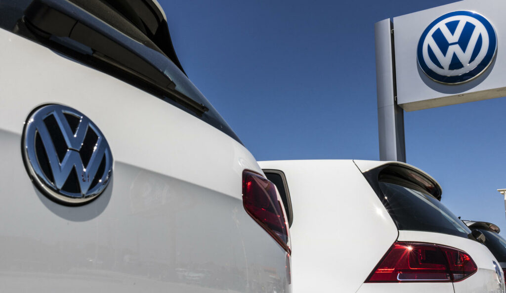 En grupp Volkswagen-bilar parkerade framför en bilhandlare. (AI text)