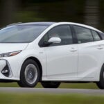 Toyota Prius kör längs en landsväg. (AI text)