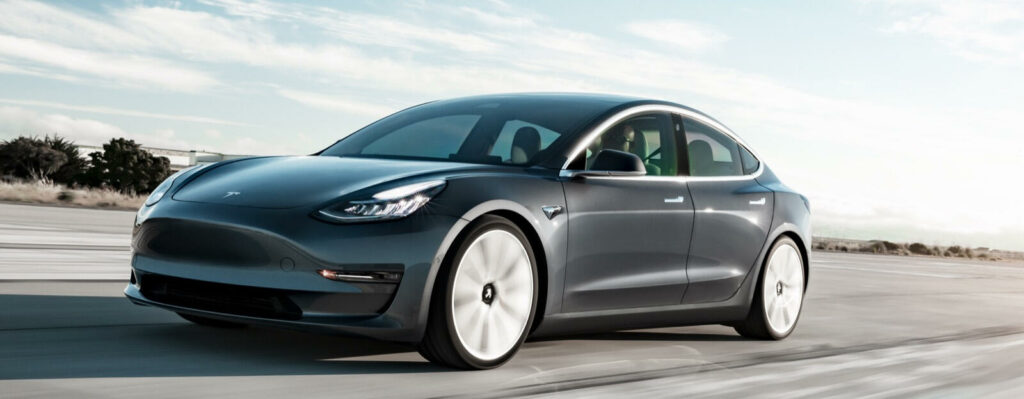 En Tesla Model 3 kör på en väg. (AI text)