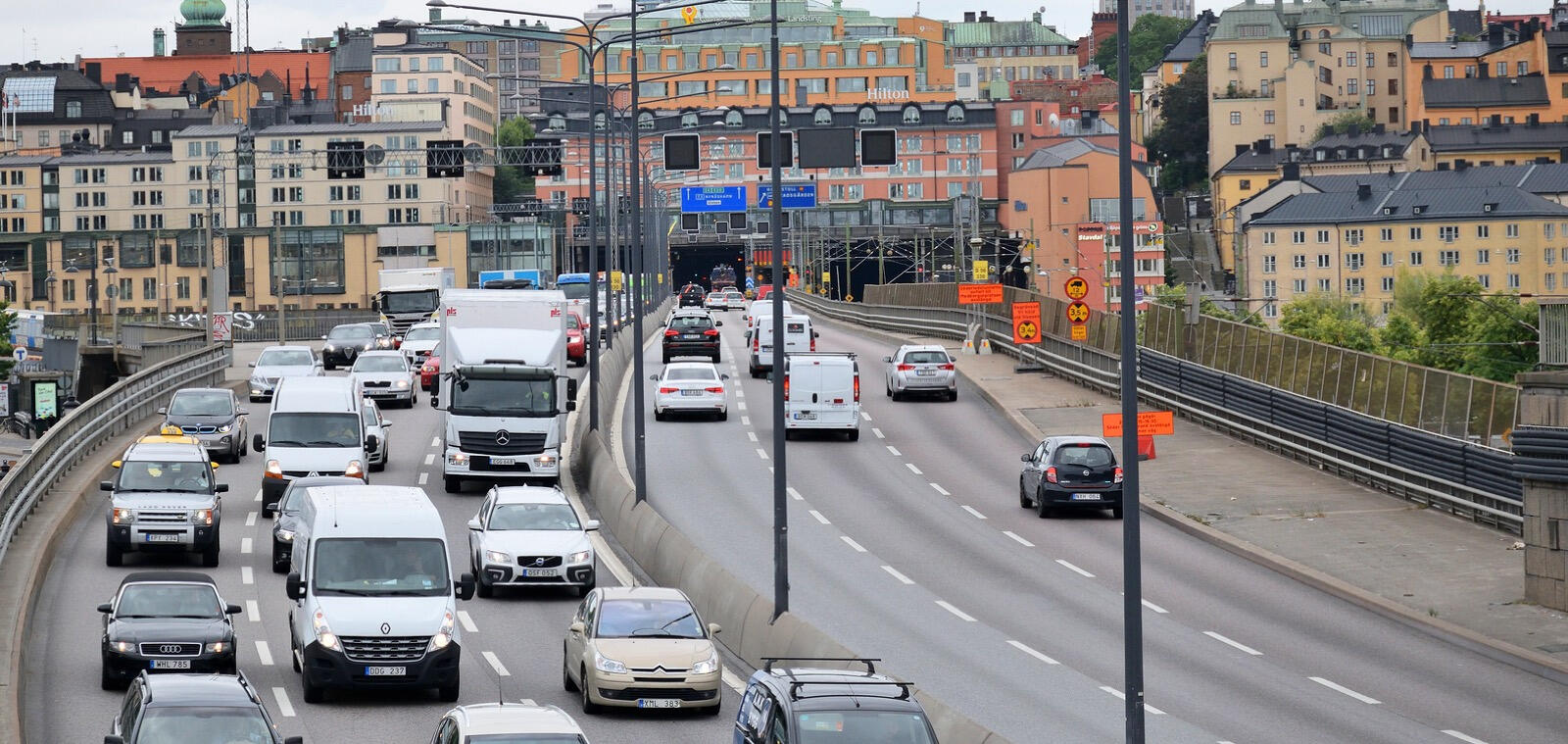 En stadsgata med bilar och folk. (AI text)