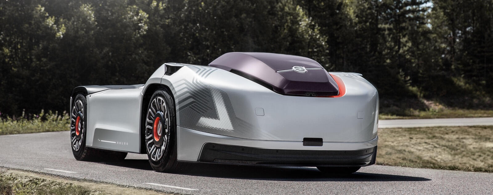 En futuristisk bil kör längs en väg. (AI text)