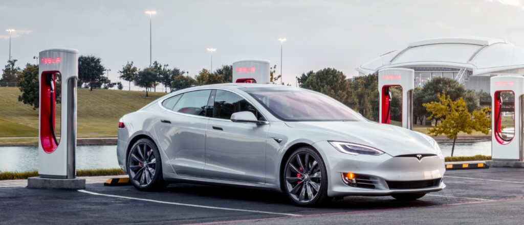 En Tesla Model S parkerad vid en elbilsladdstation. (AI text)