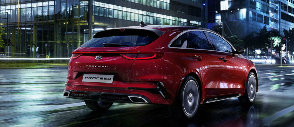 En röd Hyundai Ioniq kör på en stadsgata på natten. (AI text)