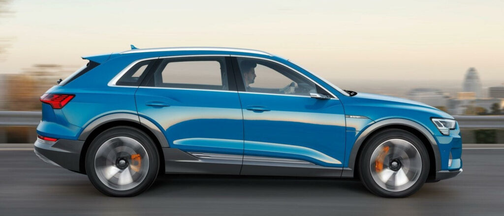 En blå Audi Q3 kör på en stadsgata. (AI text)