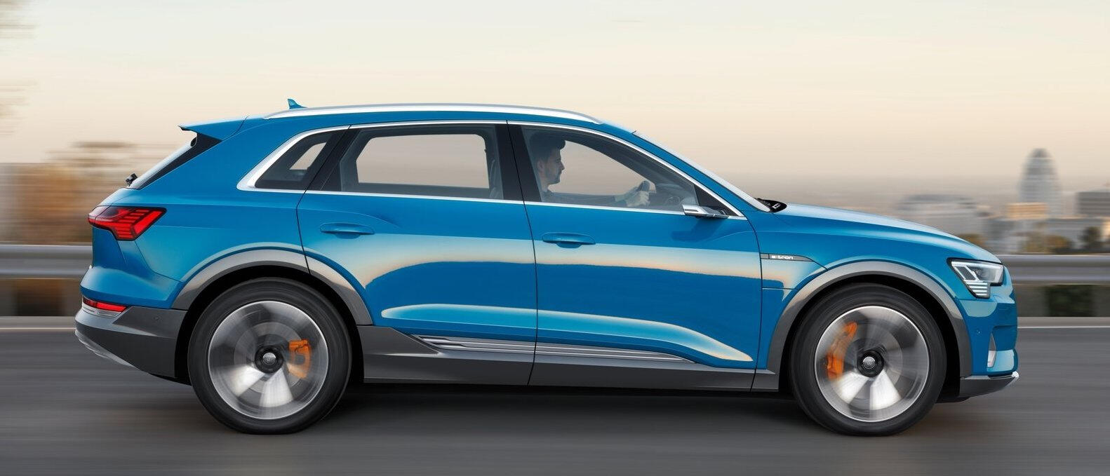 En blå Audi Q3 kör på en stadsgata. (AI text)