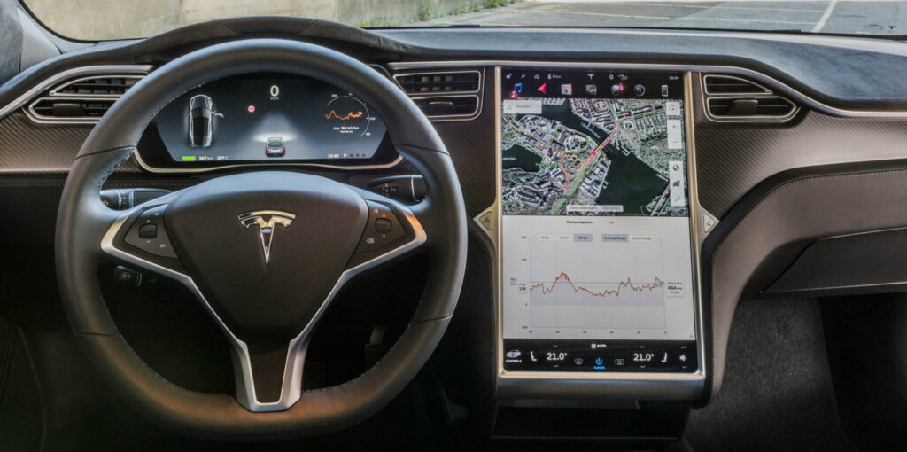 Tesla Model S-interiör med dashboardskivor och styrspak (AI text)