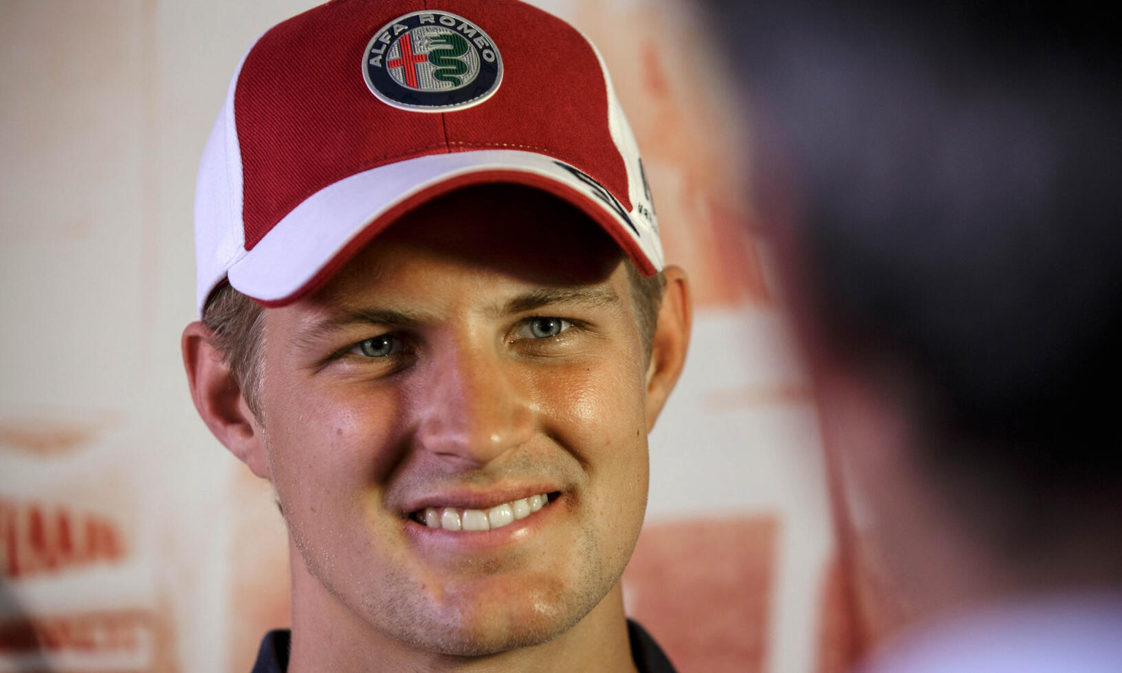 En man i en röd hatt och ett vitt skjort. (AI text)