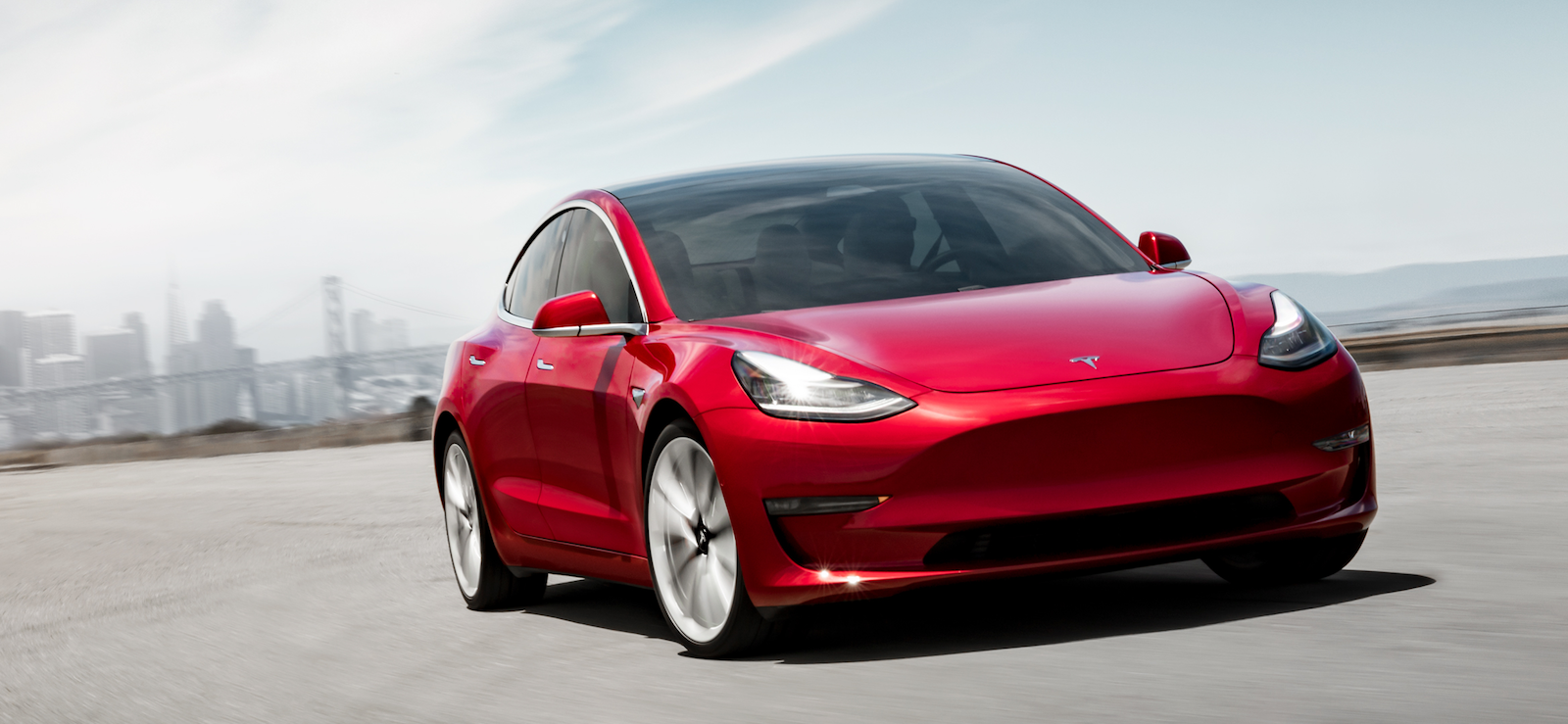 Tesla Model 3 kör på en stadsgata. (AI text)