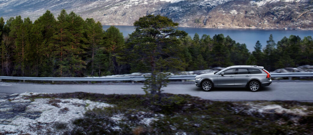 En Volvo XC90 SUV kör nerför en bergsväg. (AI text)