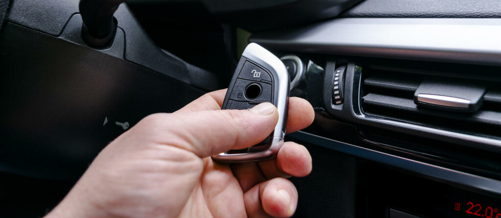 En man använder en fjärrkontroll för att öppna bilens dörre. (AI text)