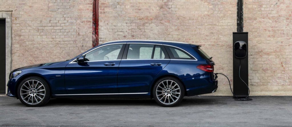 En Mercedes-Benz C-klass parkerad framför ett byggnad. (AI text)