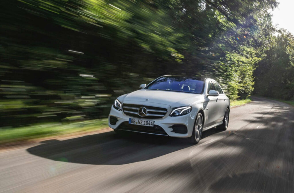 En Mercedes E-klass kör nedför en landsväg. (AI text)