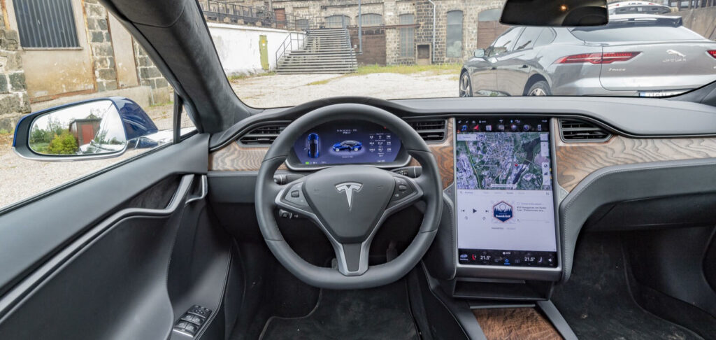 Tesla Model X-interiör med dashboardskiva och ratt (AI text)
