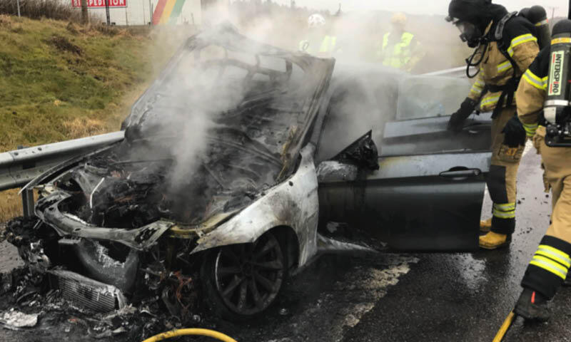 En brandman släckar en bilbrand. (AI text)