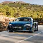 Audi R8 V10 Plus kör nedför en bergväg. (AI text)