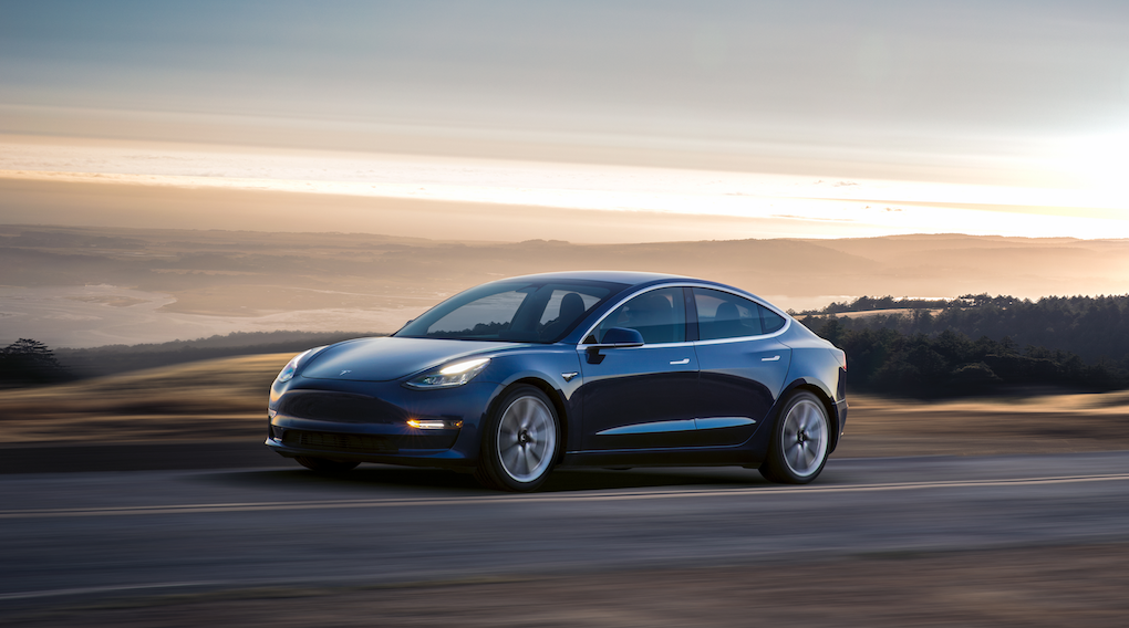 Tesla Model 3 kör på en bergsväg. (AI text)