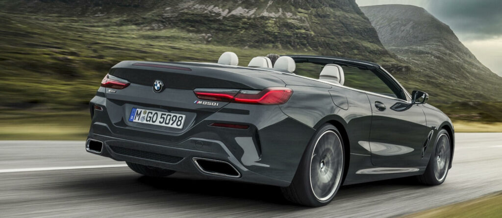 BMW M8 konvertibeln kör nerför en bergsväg. (AI text)