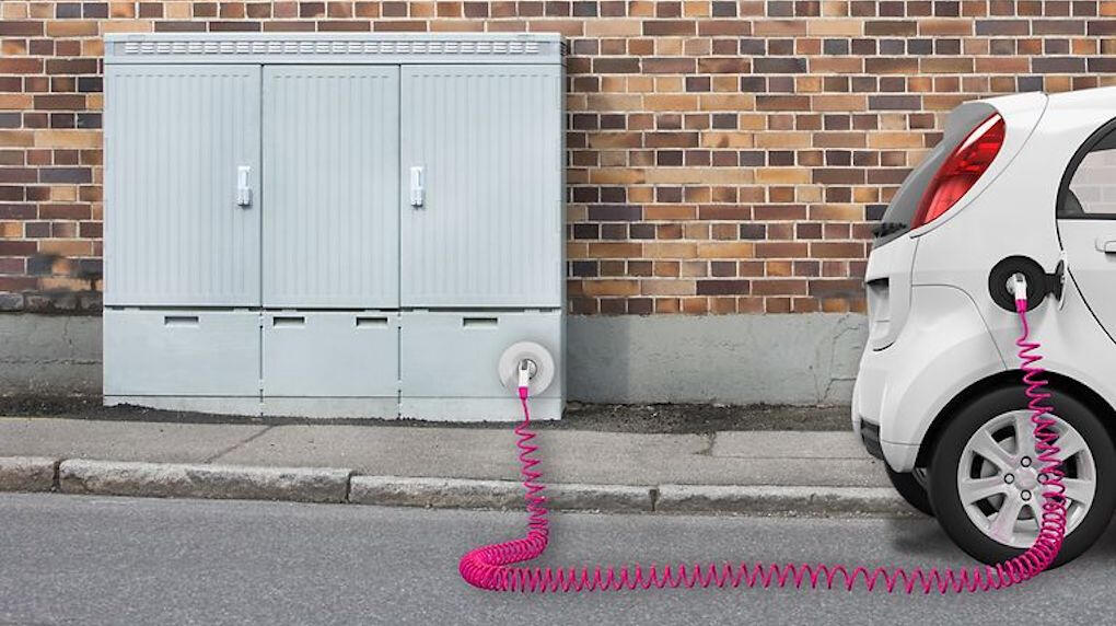 En bil är uppkopplad till en eluttag. (AI text)