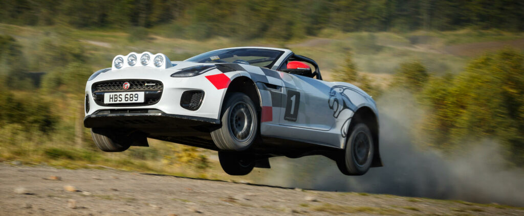 En jaguar F-Type rallybils rävsprång över en grusväg (AI text)