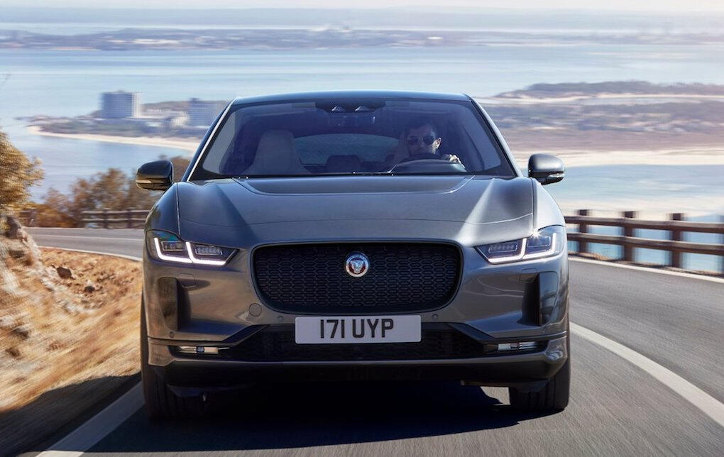 En Jaguar I Pace kör längs en väg. (AI text)