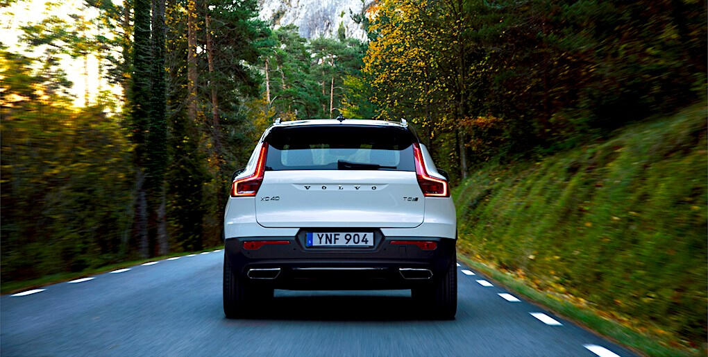 En Volvo XC90 SUV kör nedför en bergväg. (AI text)