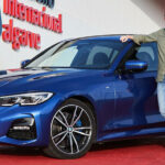 En man står bredvid en BMW M-serie. (AI text)