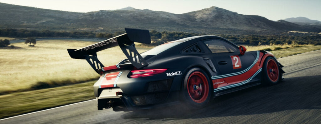 En Porsche 911 GT3 RS kör nedför en bergig väg. (AI text)