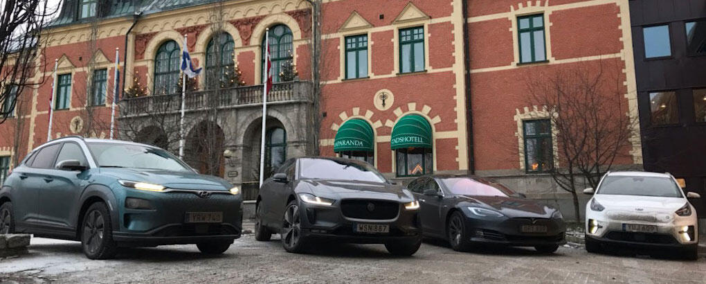 En grupp bilar står parkerade framför ett byggnad. (AI text)