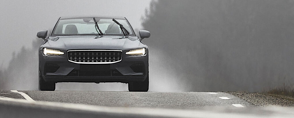 En SUV körs nedför en väg i dimma. (AI text)