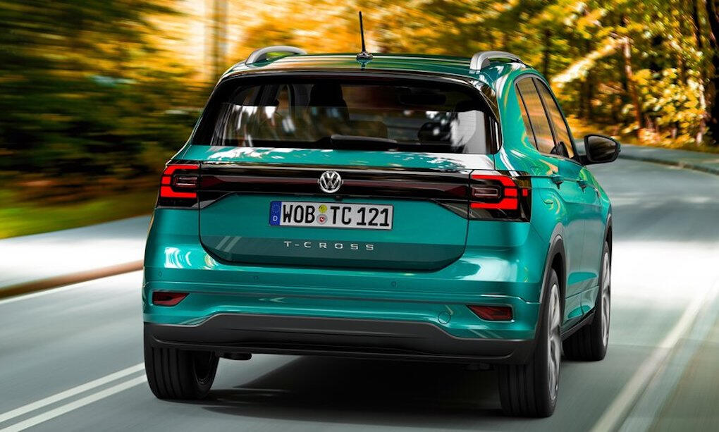 En grön Volkswagen T-Cross kör längs en landsväg. (AI text)