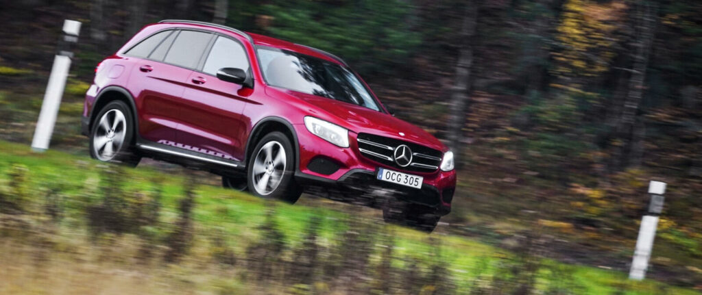 Mercedes GLC kör nedför en backe. (AI text)