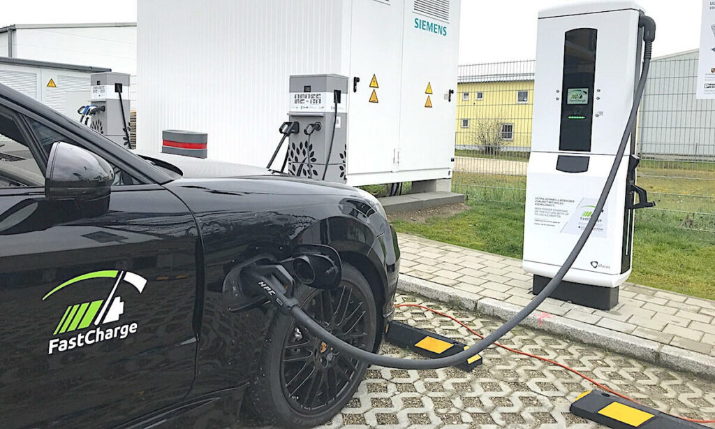 En svart bil är uppladdad vid en elbilsladdstation. (AI text)