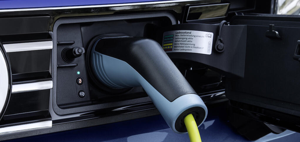 En blå bil är uppkopplad till en elladdare. (AI text)