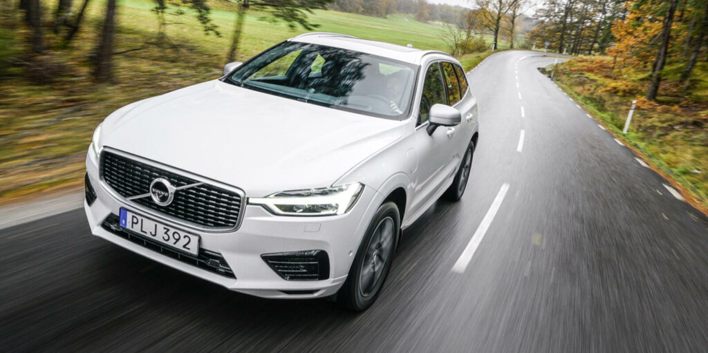 Volvo XC90-fordonet kör längs en landsväg. (AI text)