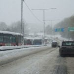 En bil kör nerför en snöig väg. (AI text)