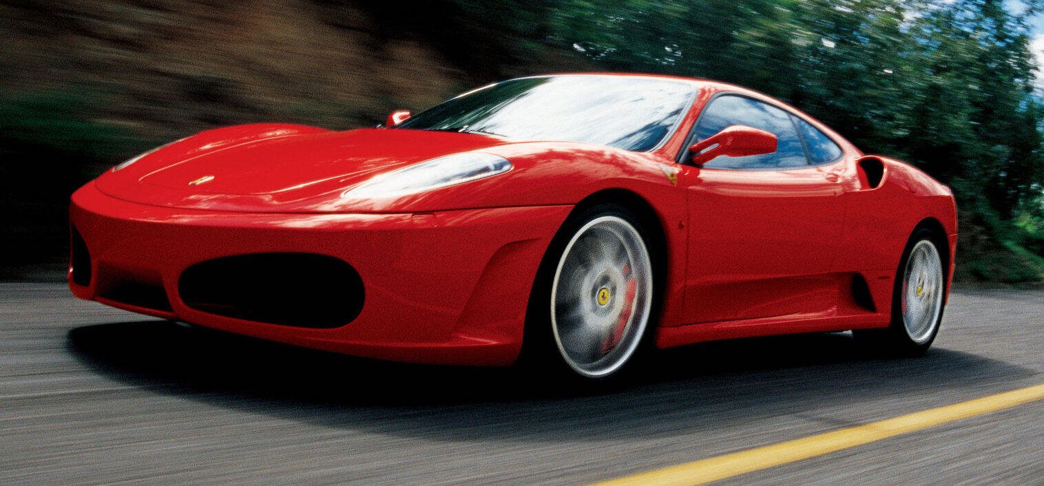 En röd sportbil kör nerför en väg. (AI text)