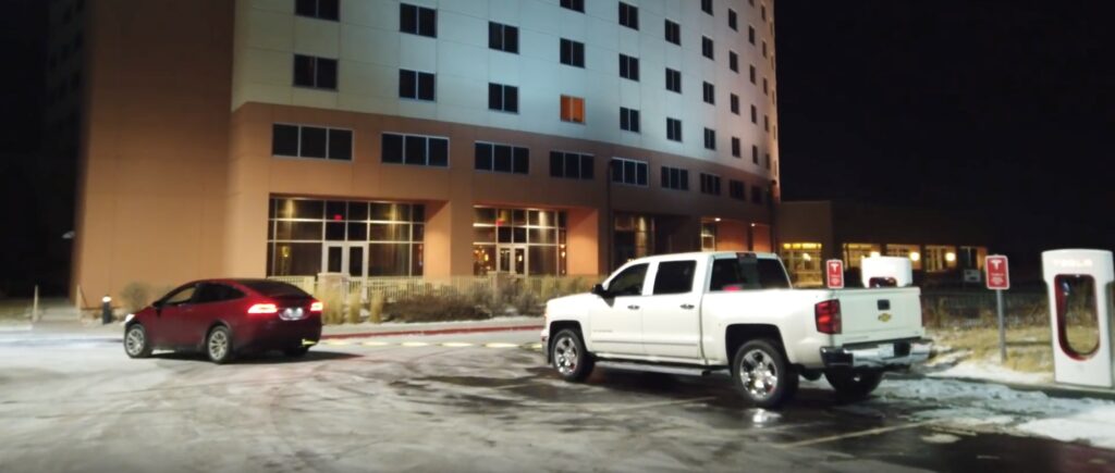 En bil parkerad framför ett hotell. (AI text)