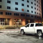 En bil parkerad framför ett hotell. (AI text)