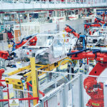 En fabrik med robotar som arbetar på bilar. (AI text)