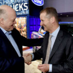 Två män skakar hand inför en Ford-pickup. (AI text)