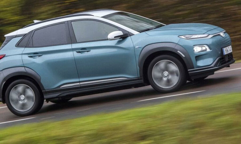 Den nya Hyundai Kona kör nerför en landsväg. (AI text)